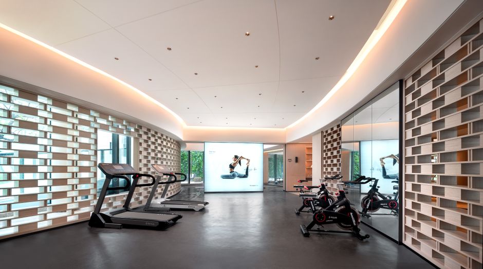 Imagem de uma academia moderna com esteiras, bicicletas ergométricas e um espaço de treino, destacando um ambiente de atividades físicas e bem-estar.